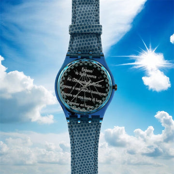 Wristwatch with textured strap and black face against a blue sky background.
