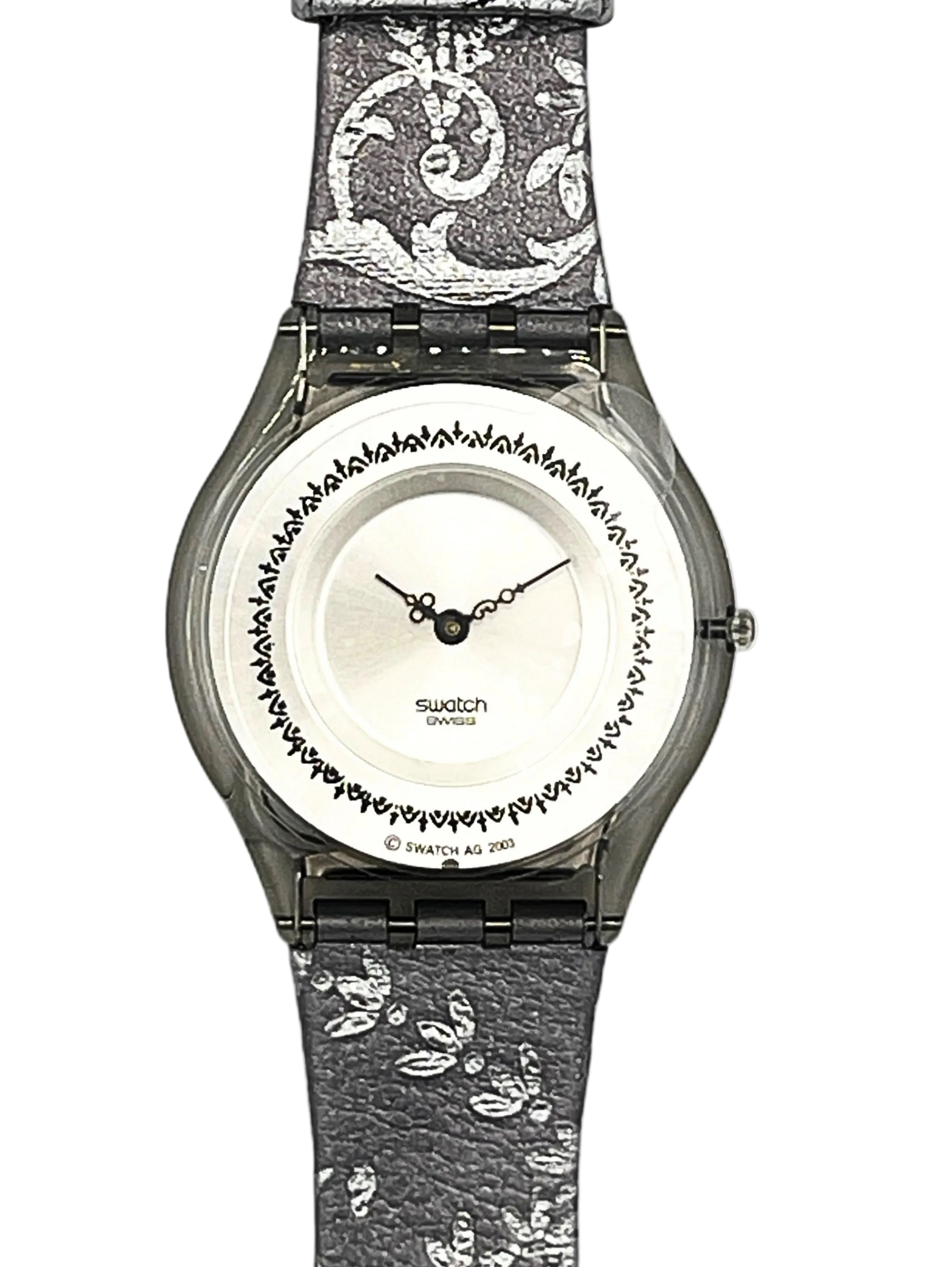 Swatch London analog watch with a textured gray and white patterned strap, a silver-toned case, and a white dial featuring a black decorative border.