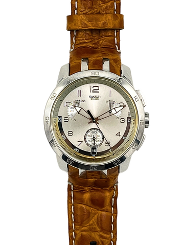 A Swatch wristwatch featuring a brown textured alligator leather strap and a silver-toned stainless steel case with a white dial.