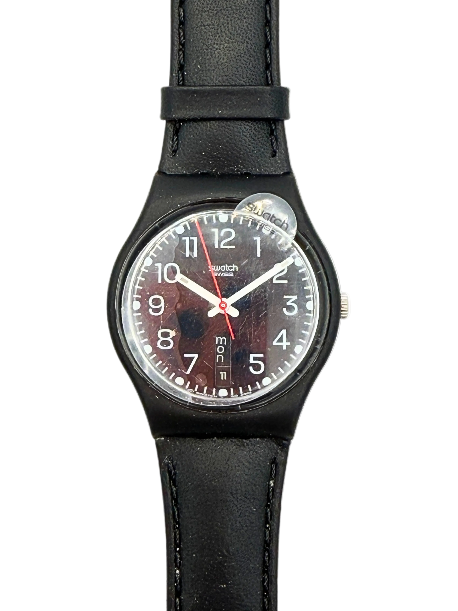 A Swatch wristwatch with a black leather strap, black case, and a dark brown textured dial with white numerals and hands.