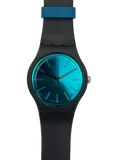 A modern analog wristwatch with a matte black silicone strap and case, featuring a vibrant metallic teal-blue gradient dial and a matching blue accent ring near the top of the strap, shown against a plain white background.
