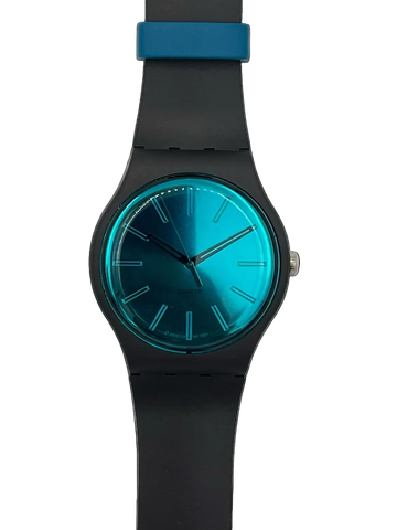 A modern analog wristwatch with a matte black silicone strap and case, featuring a vibrant metallic teal-blue gradient dial and a matching blue accent ring near the top of the strap, shown against a plain white background.