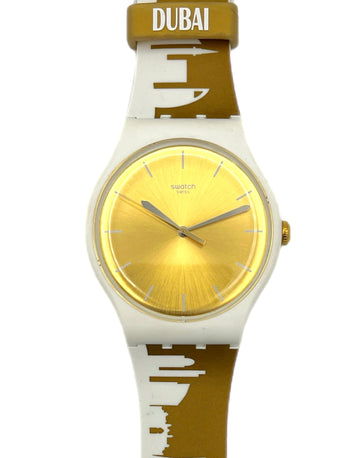 Watch with gold face and white and brown strap on a white background