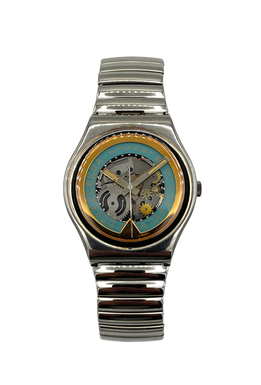 A wristwatch with a silver-tone metal link bracelet and a round case. The dial is open-heart style, showing a turquoise blue background with gold-tone hands and a visible mechanical gear movement inside.