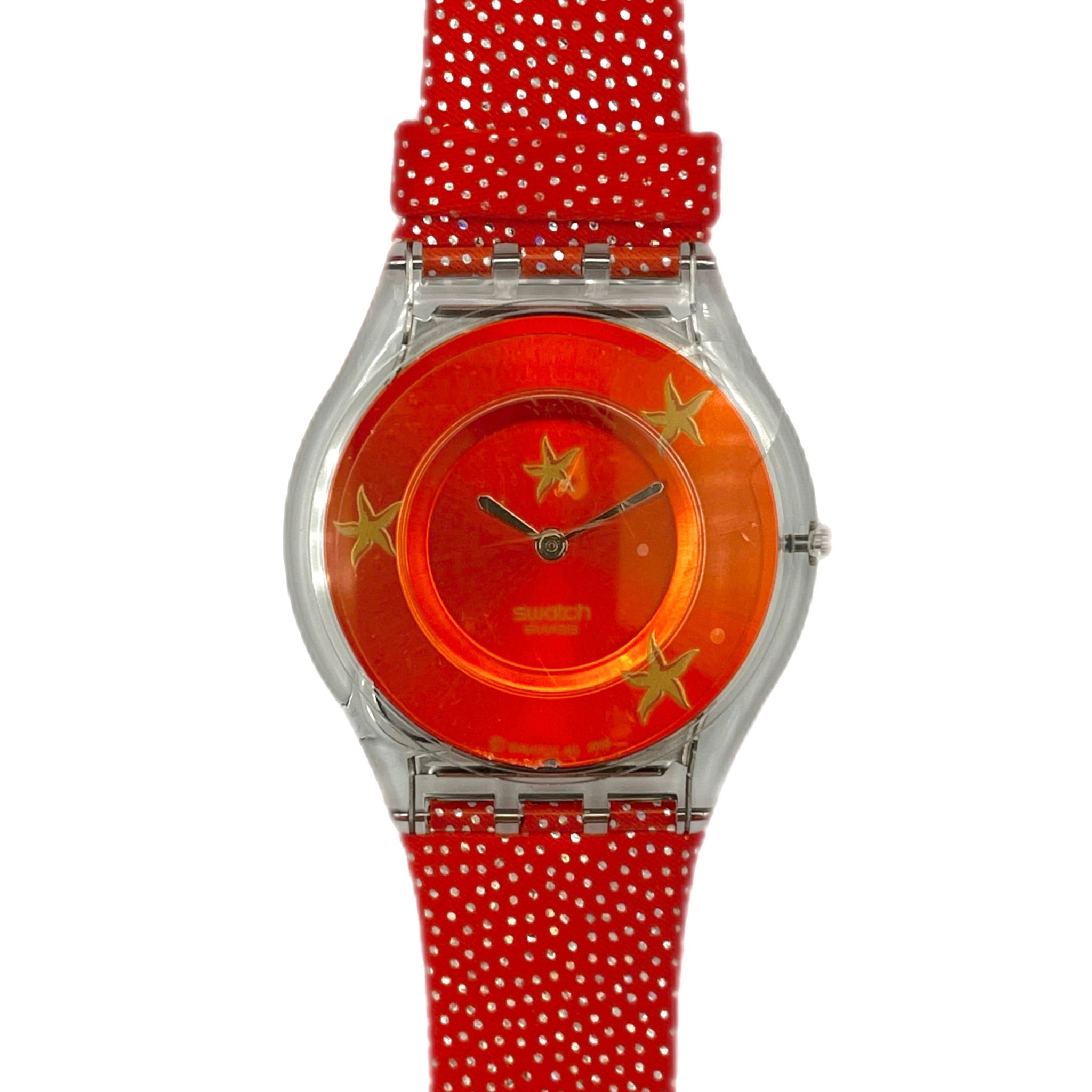 Wristwatch with red strap and orange face featuring stars on a white background