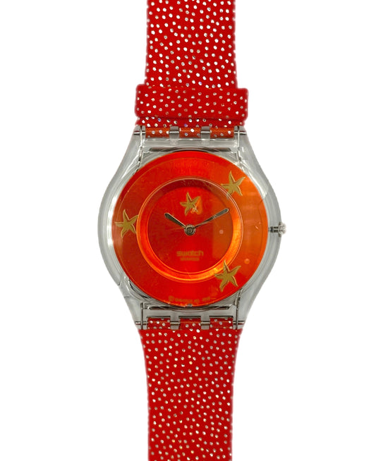 Wristwatch with red strap and orange face featuring stars on a white background