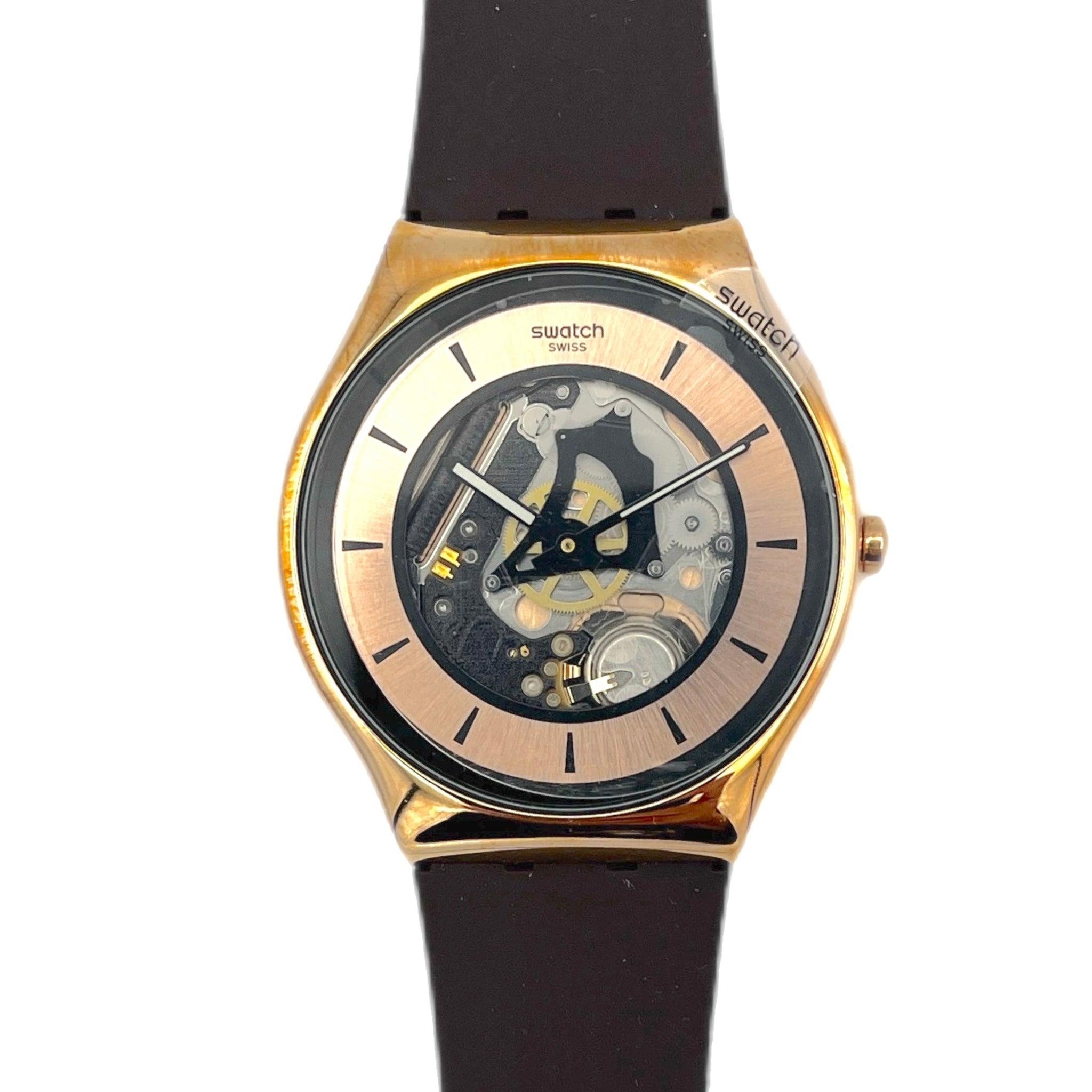 Swatch watch with black strap and gold case on a white background