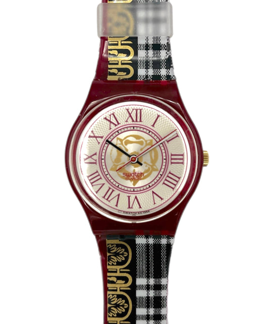 Watch with a red strap featuring a checkered pattern and gold accents on a white background