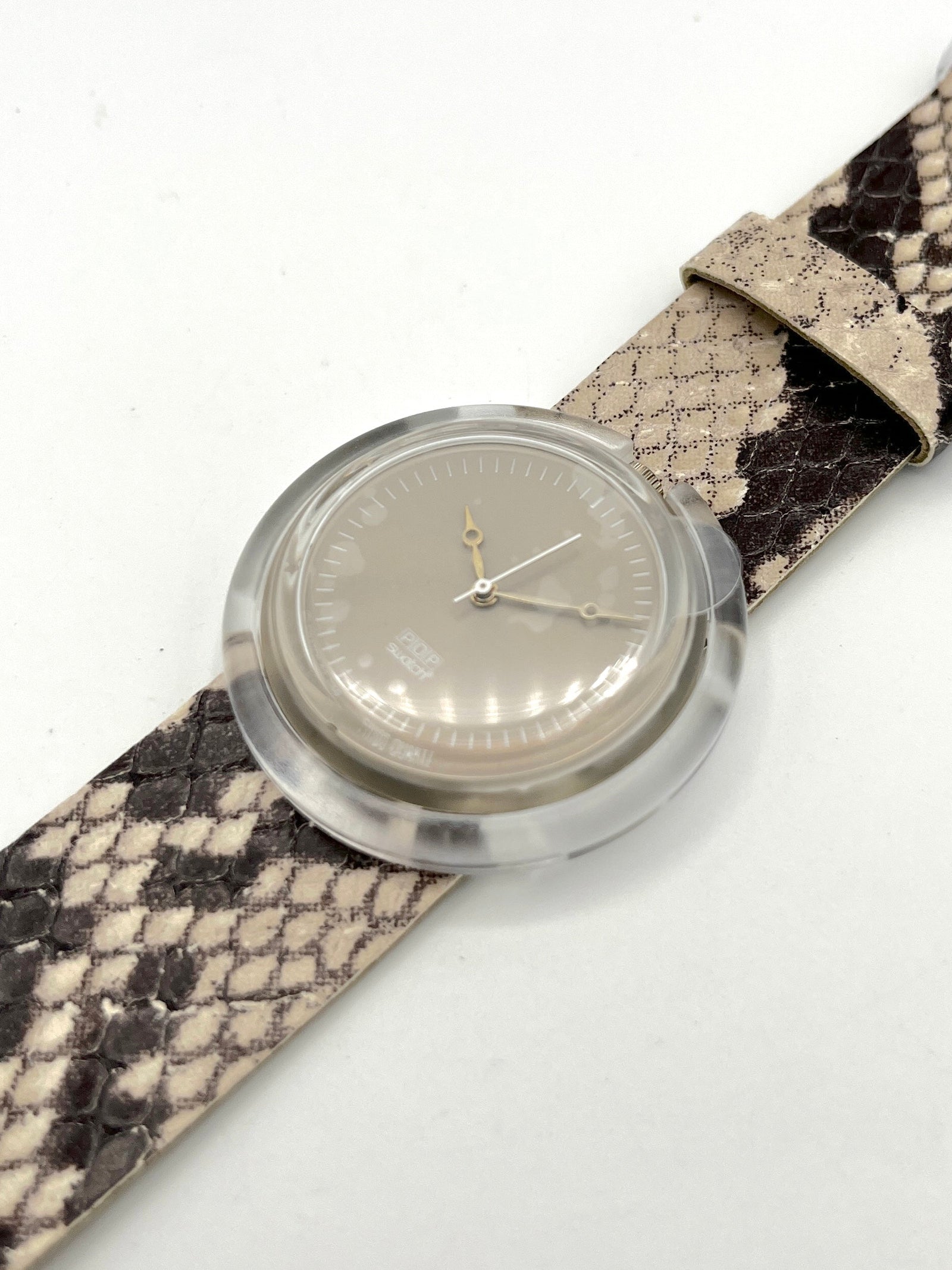 Watch with a snake skin strap on a white background