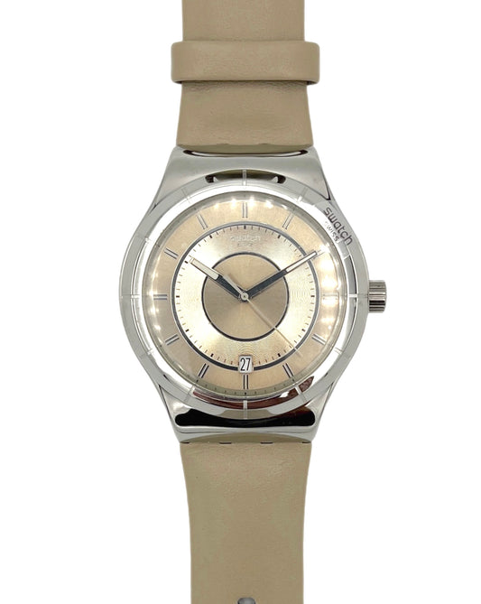 Swatch watch with beige strap and face on a white background