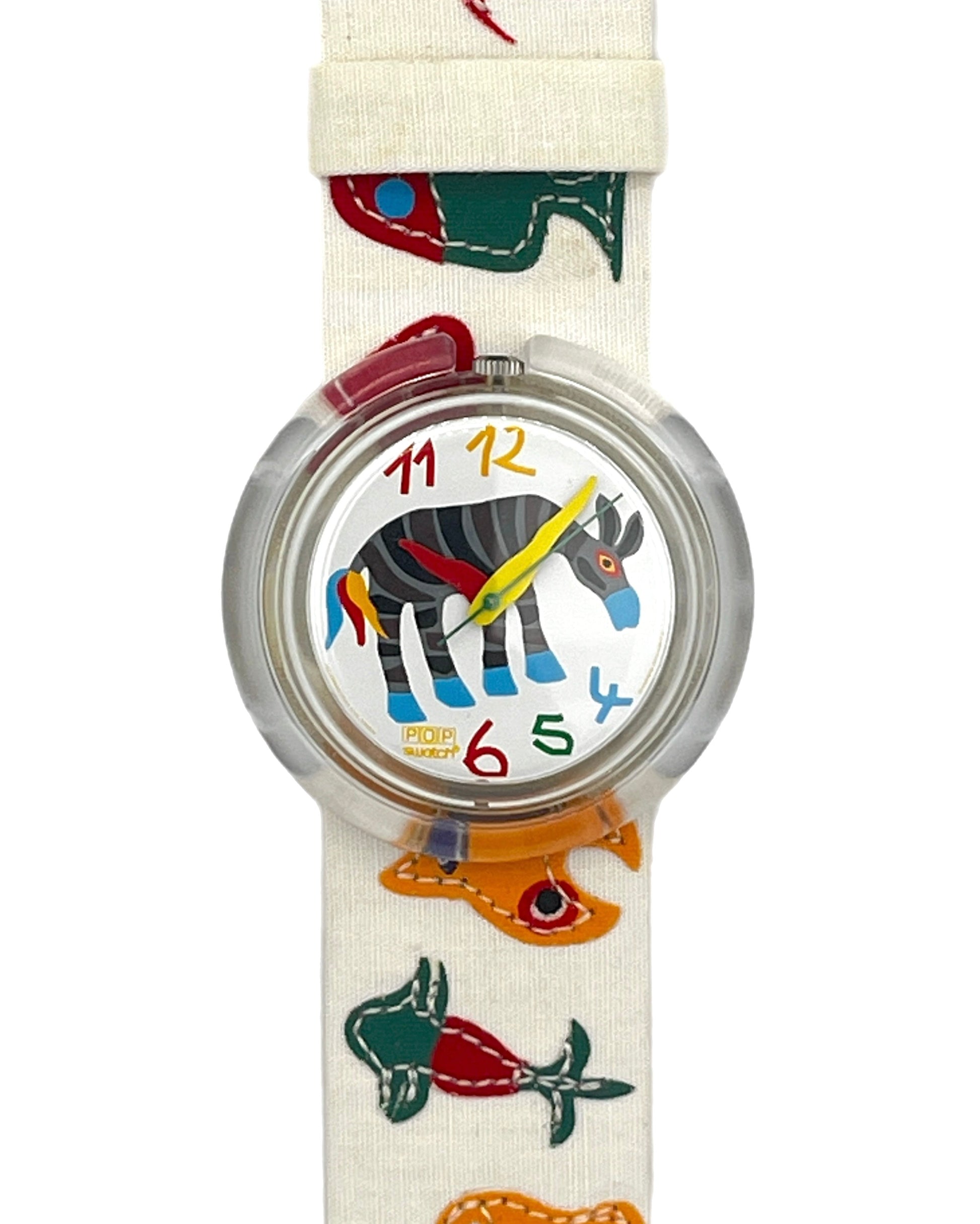 A children's wristwatch with a cream-colored fabric strap decorated with colorful embroidered animal silhouettes, featuring a round clear case and a white dial with a zebra illustration and colorful numbers.