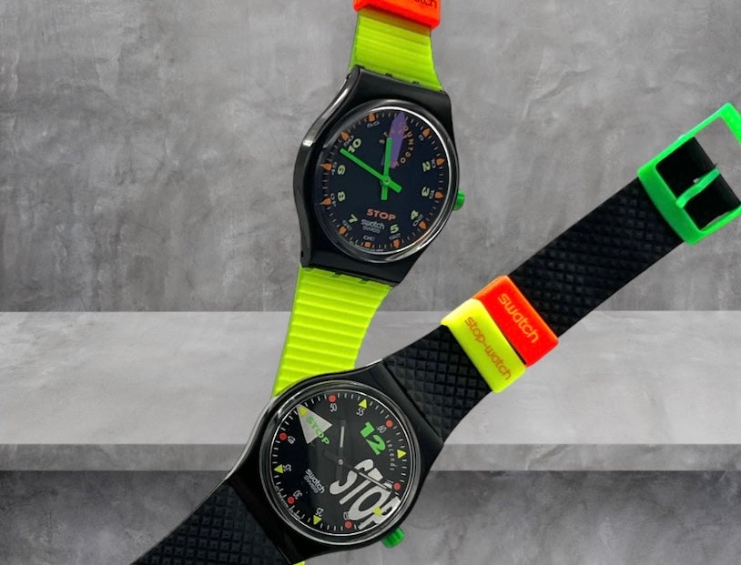 A new, unopened replacement band for a Pop Swatch watch, featuring a vibrant orange textile strap with a matching orange dial, packaged in a clear plastic case.