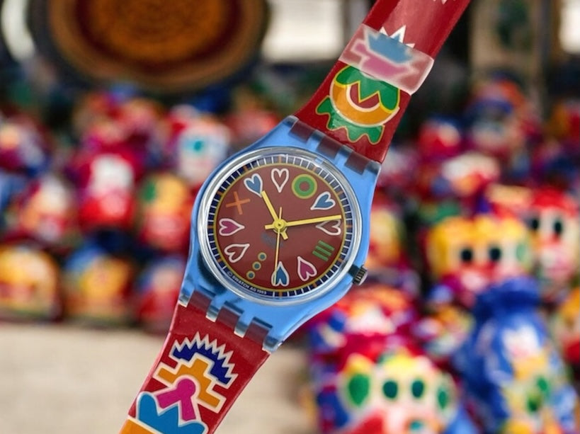 A new, unopened replacement band for a Pop Swatch watch, featuring a vibrant orange textile strap with a matching orange dial, packaged in a clear plastic case.
