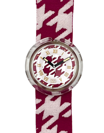 A Swatch watch featuring a burgundy and white houndstooth patterned strap, a clear protective case, and a white dial with Roman numerals and a burgundy logo.