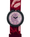 A Swatch wristwatch featuring a burgundy and pink patterned fabric strap, a black round bezel, and a lavender-purple dial with pink dot hour markers.