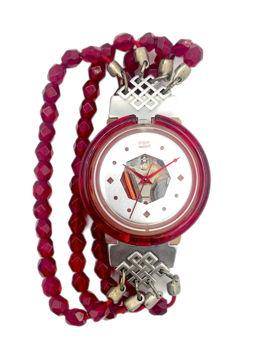 Watch with a red beaded strap and silver accents on a white background