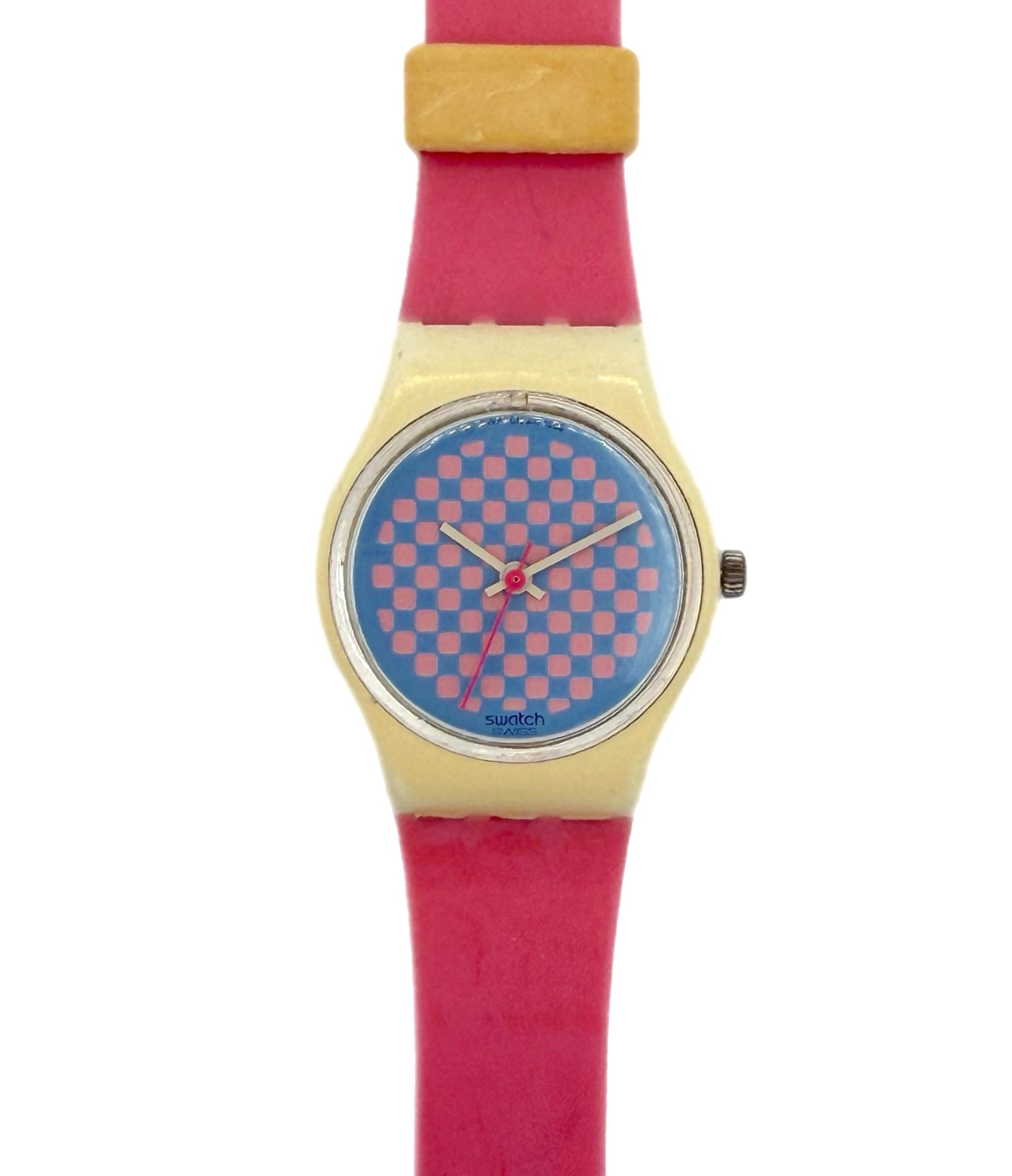 A Swatch wristwatch featuring a bright pink strap, a gold-tone case, and a blue dial with a pink checkerboard pattern.