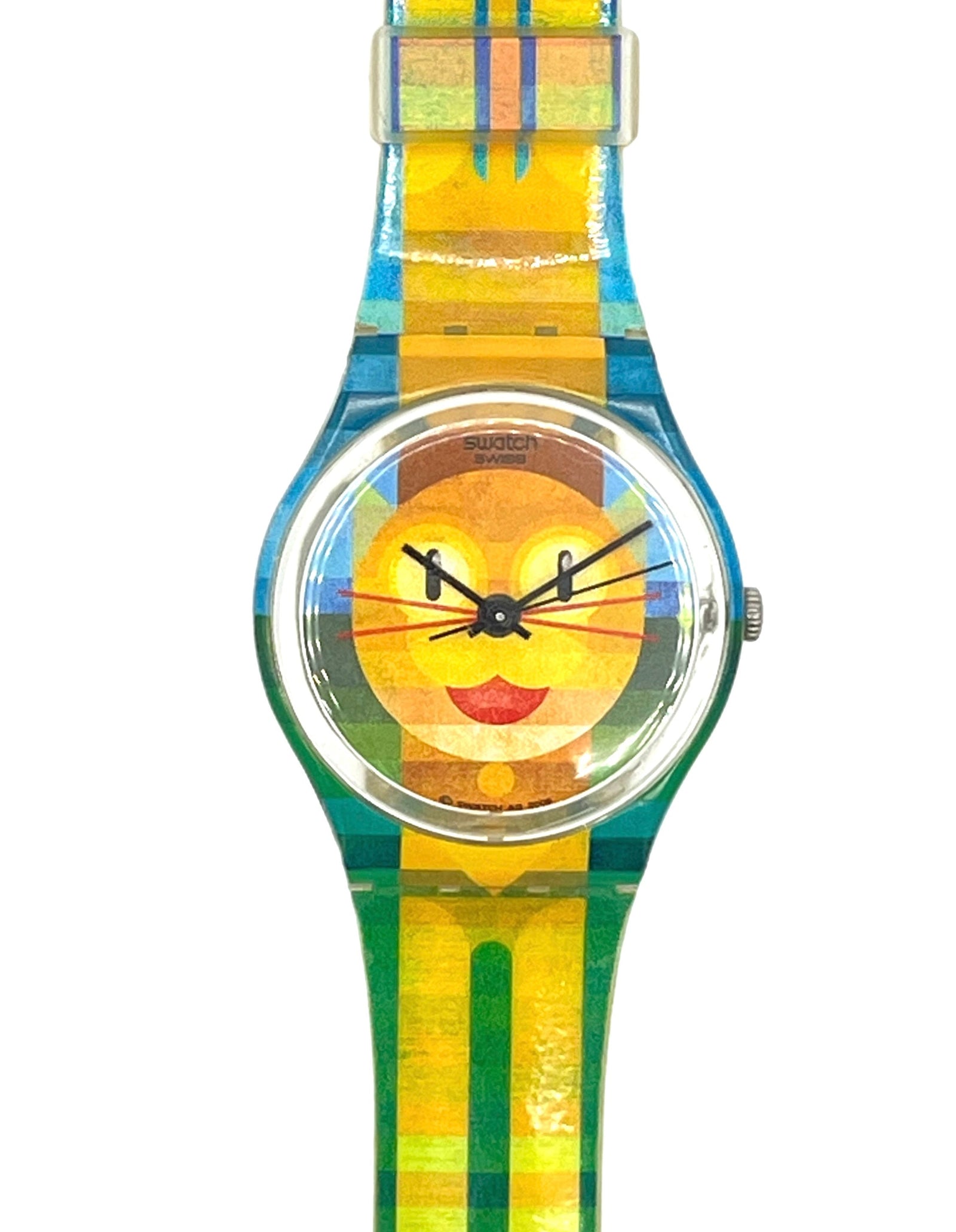 A wristwatch with a colorful striped and plaid strap in yellow, green, and blue, featuring a round clear crystal case and a yellow dial with a stylized face design.