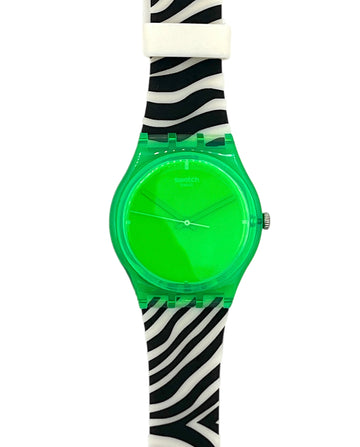 A Swatch wristwatch featuring a translucent neon green case and dial, paired with a black and white zebra print strap.