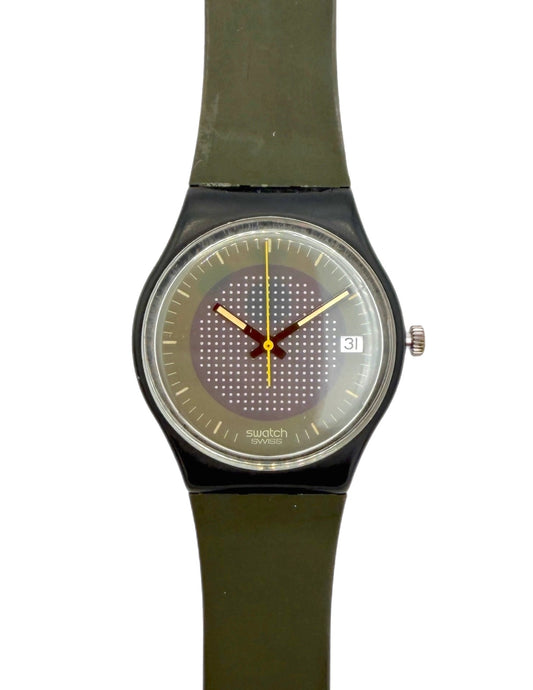 Swatch wristwatch with an olive green strap, black case, and a textured gray dial with gold hands.