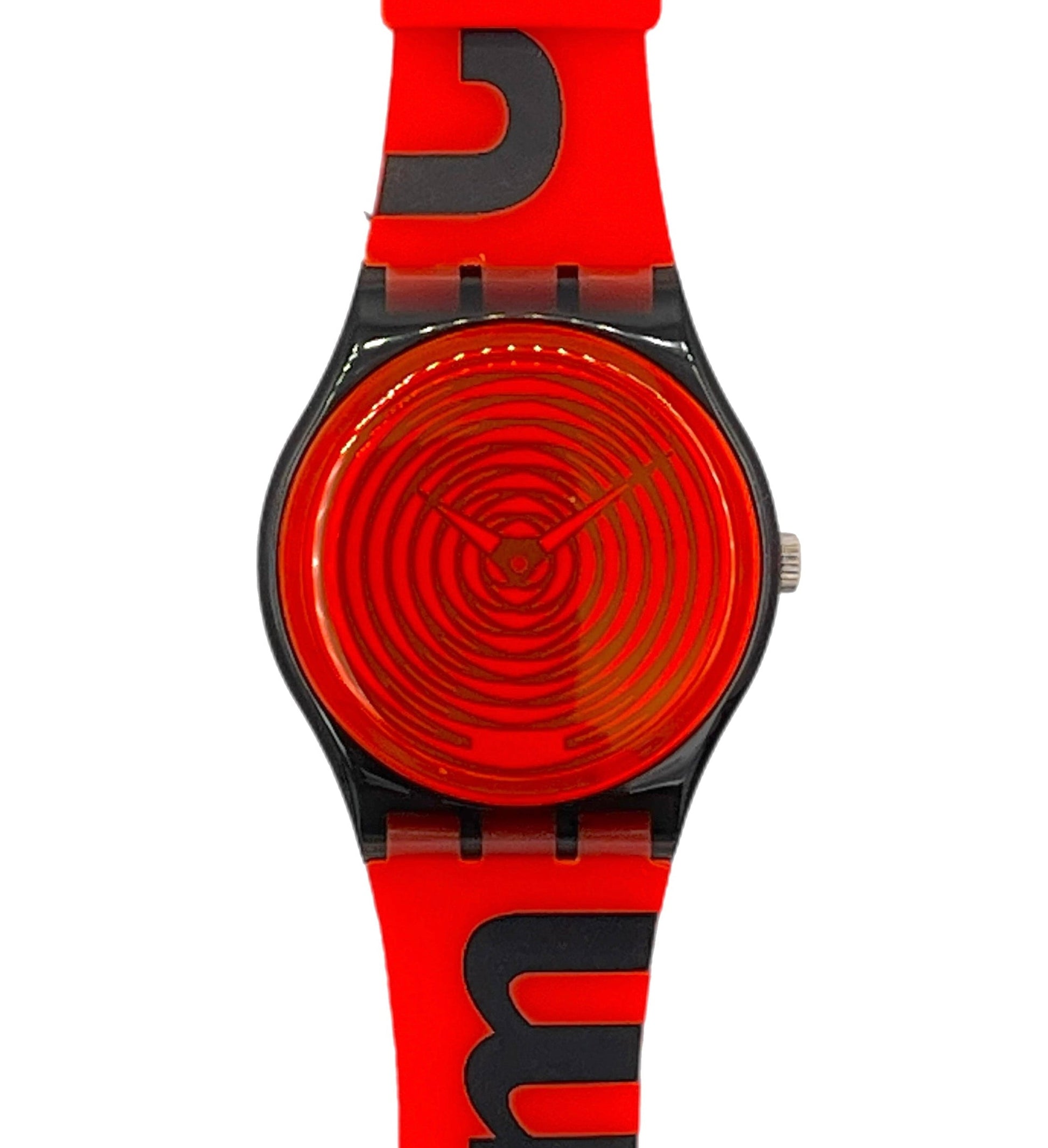 A Swatch wristwatch featuring a bright red silicone strap and matching red dial with black concentric spiral details, black bezel, and bold black lettering on the strap.