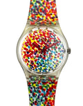 A Swatch wristwatch featuring a clear case, a colorful confetti dial, and a matching translucent strap with a vibrant multicolor speckled pattern.