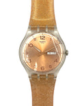 Swatch watch with a gold strap and face on a white background