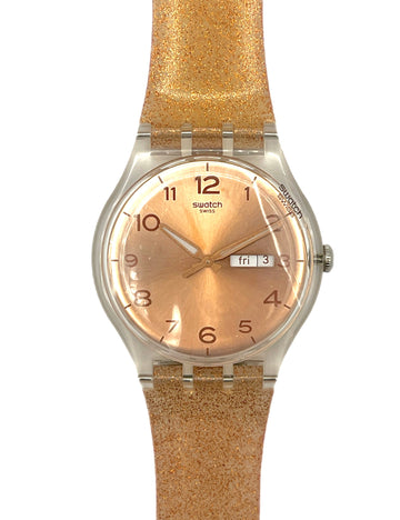 Swatch watch with a gold strap and face on a white background