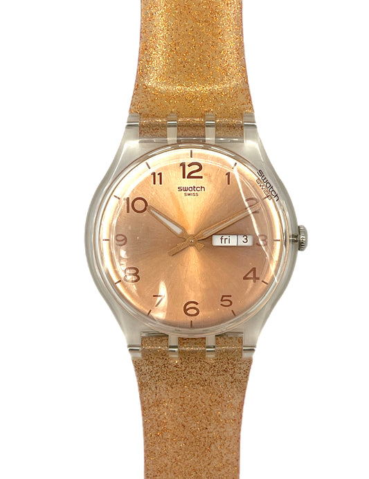 Swatch watch with a gold strap and face on a white background