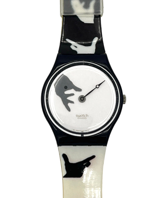 Swatch wristwatch with a glossy black and white handprint patterned strap and a white dial featuring a gray hand graphic.