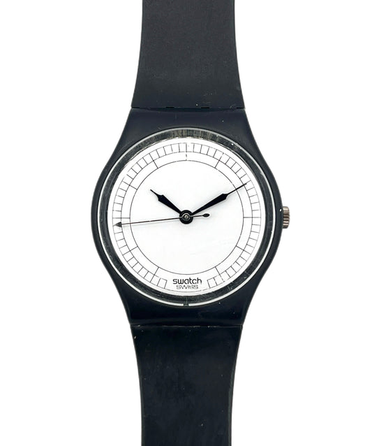 A Swatch wristwatch with a black silicone strap, black case, and a minimalist white dial with black hands.