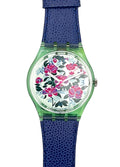 A Swatch watch featuring a textured blue strap, a translucent green case, and a white dial decorated with a vibrant pink and red floral pattern.