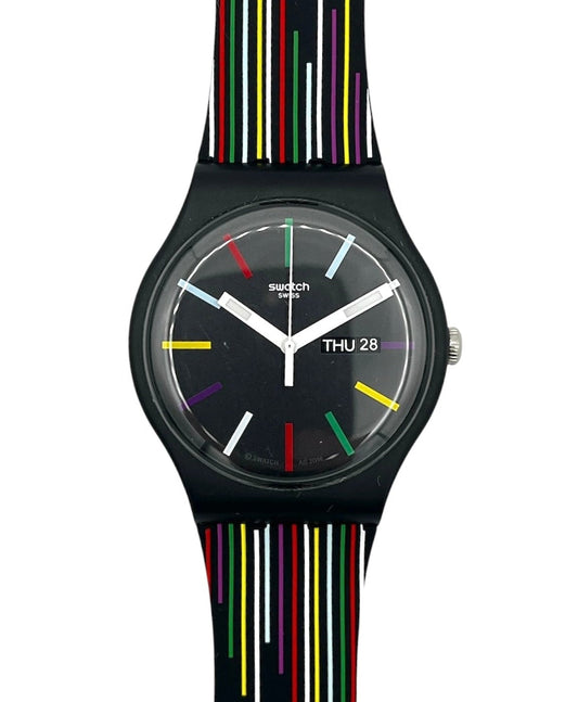 Swatch wristwatch with a black round case and a black strap featuring vertical multicolor stripes in red, yellow, green, white, and blue, shown against a plain white background.