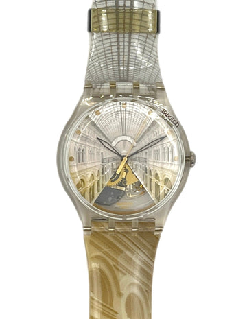 A Swatch wristwatch featuring a clear case and a strap printed with an architectural archway pattern, with a gold-toned center accent on the dial.