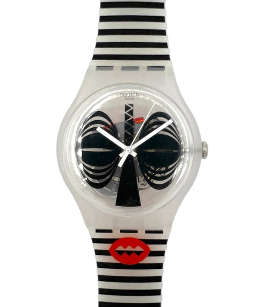 A Swatch wristwatch featuring a clear plastic case, black and white striped strap, and a unique dial with black spiral hands and a red lips logo near the bottom.