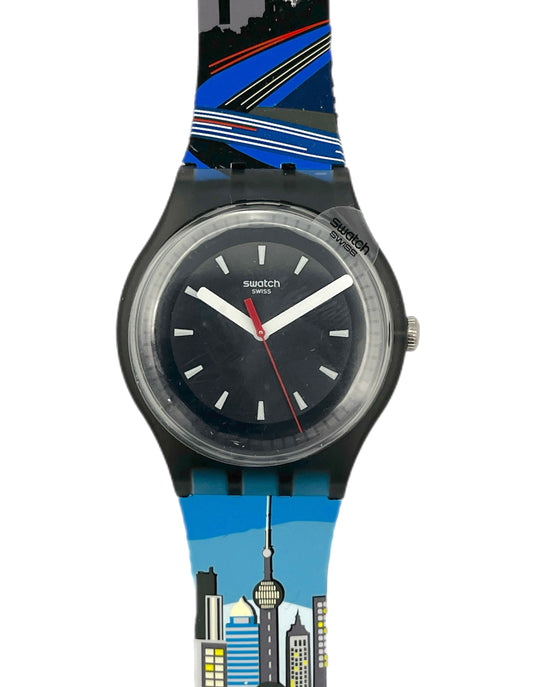 Swatch watch with a cityscape design on the strap against a white background