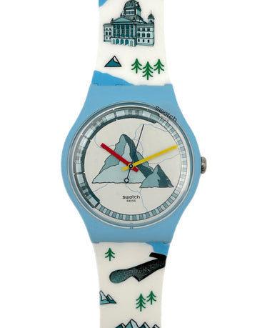 Swatch watch with a mountain and tree design on the strap against a white background