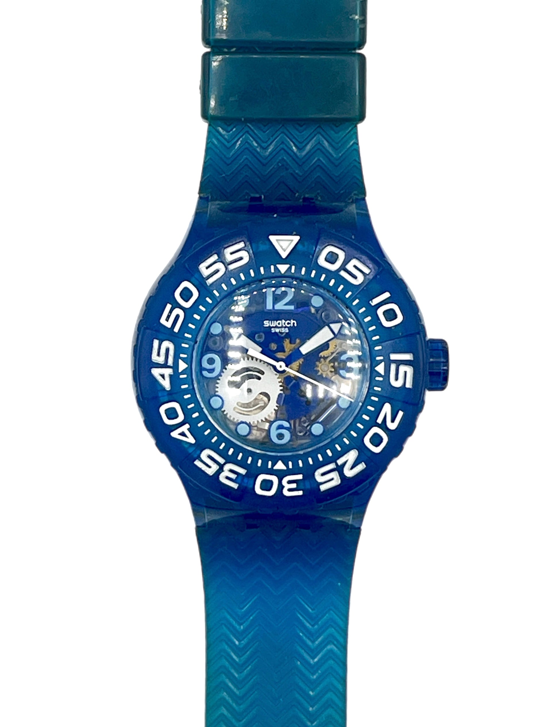 A Swatch wristwatch featuring a translucent blue silicone strap and bezel, a blue dial with white numerals, and a visible mechanical movement through the transparent case.