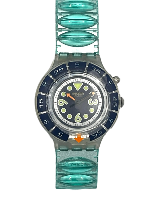 A Swatch wristwatch featuring a translucent aqua green silicone link strap and a dark blue bezel with a matching dial, shown against a plain white background.