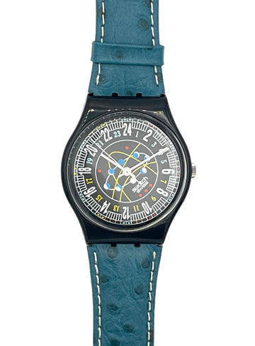 A wristwatch with a textured blue strap, a black case, and a detailed multicolor space-themed dial featuring a rocket and the words 'SPACE ZOOM'.
