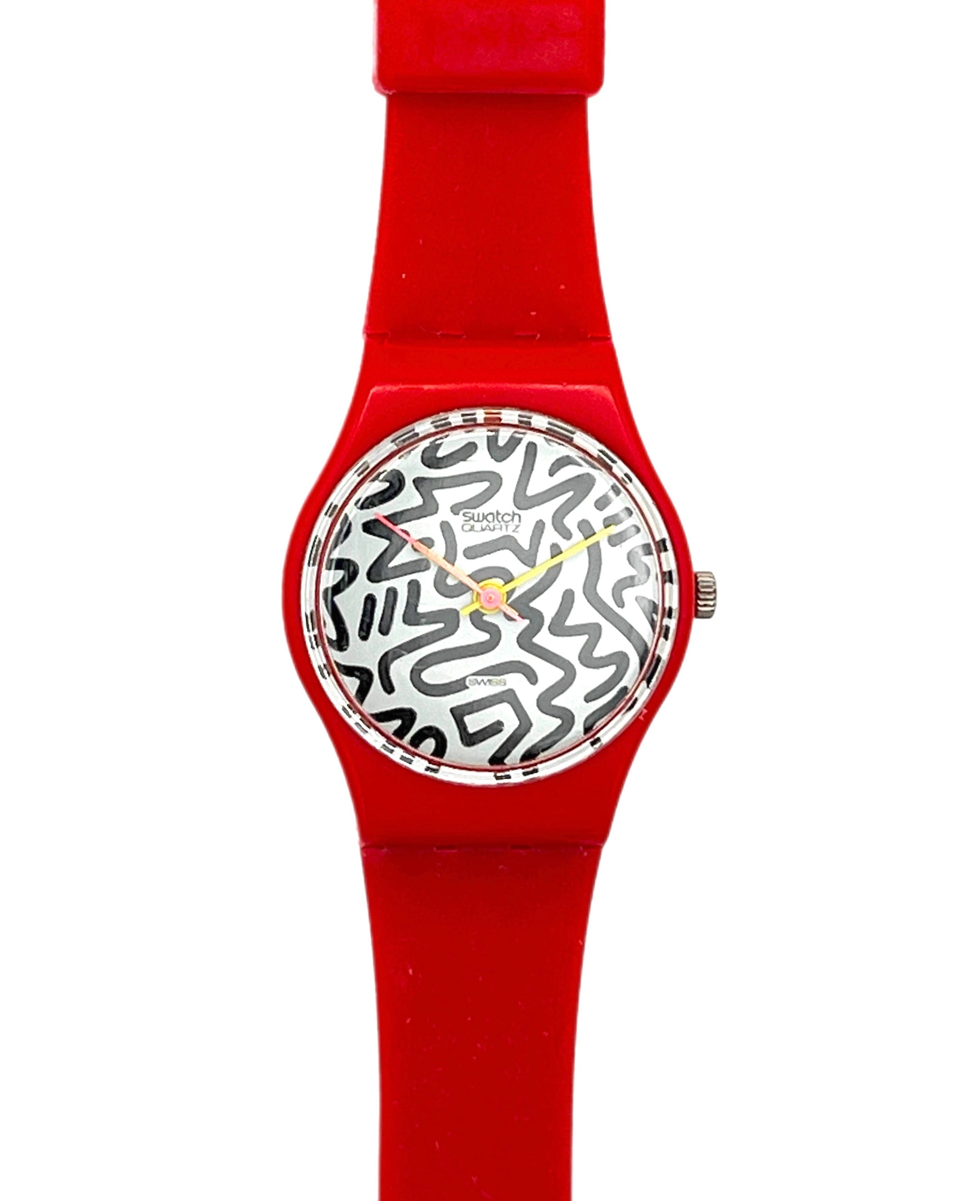 A Swatch wristwatch featuring a bright red silicone strap and case, with a white dial decorated in a black abstract line pattern and yellow hands.