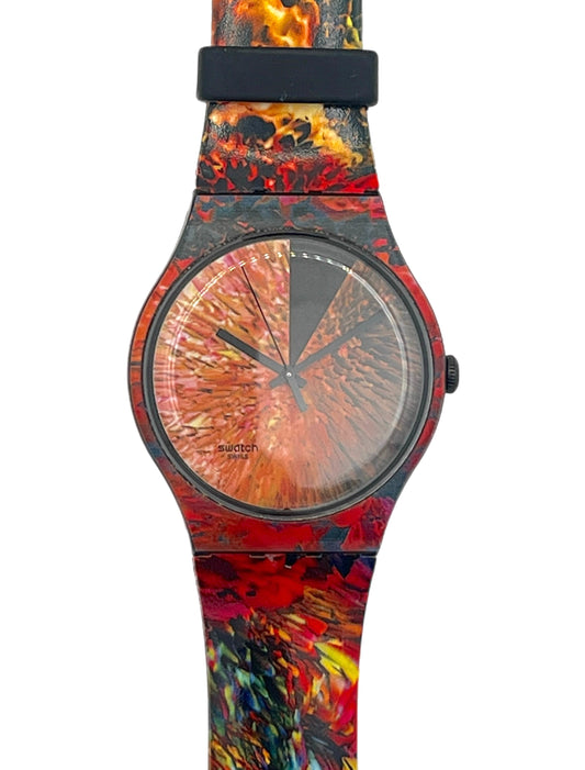A wristwatch with a round black bezel and a strap featuring a vibrant, abstract fiery pattern in red, orange, yellow, and black, shown against a plain white background.