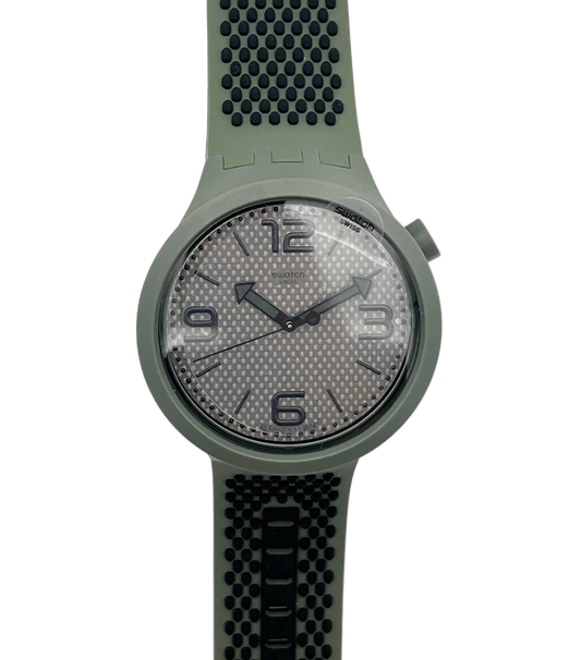 A Swatch wristwatch featuring an olive green silicone strap and case, with a textured gray dial and black numerals.